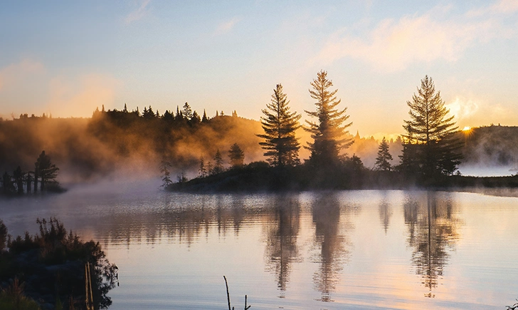 Calm waters in the early morning with mist in the air