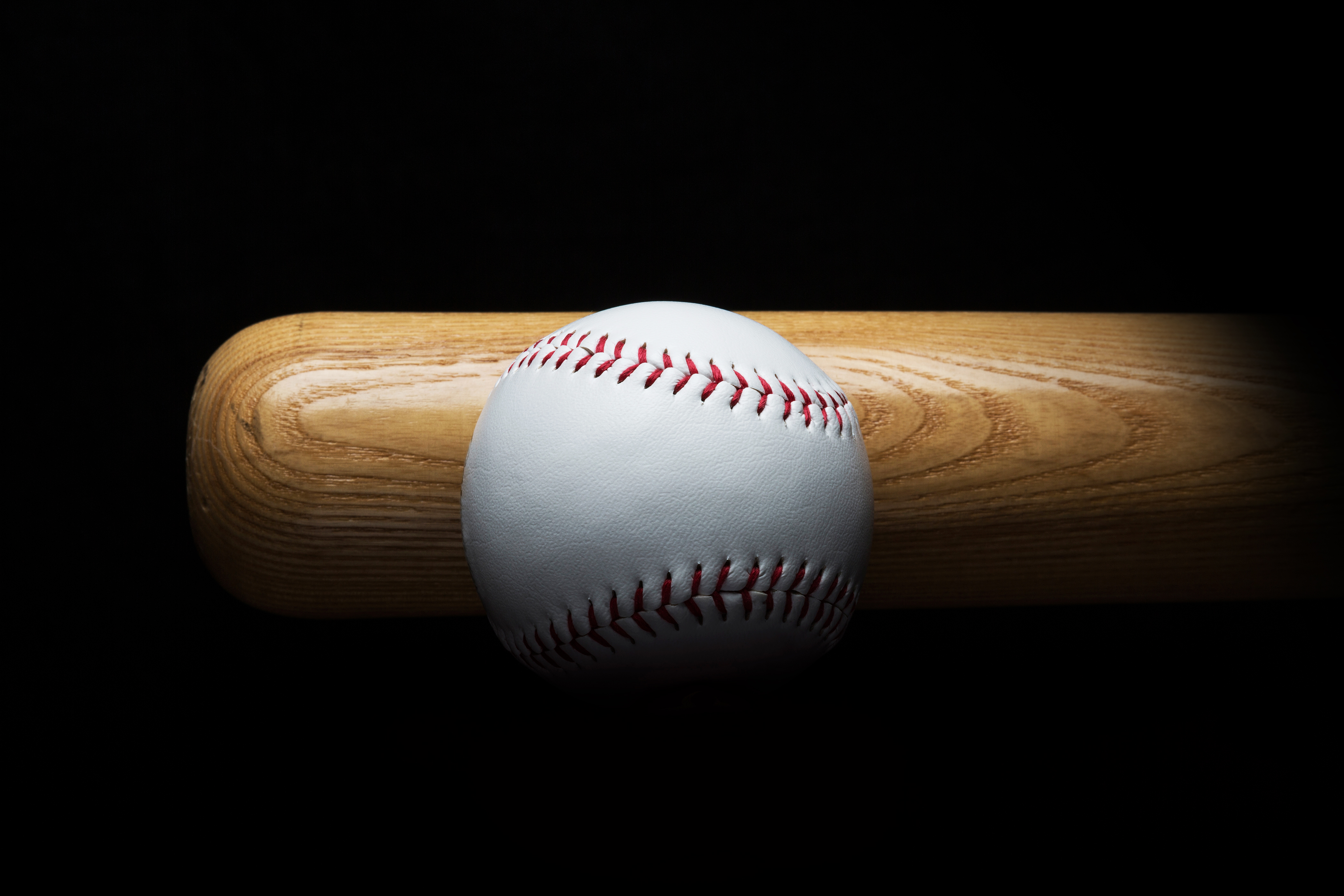 Baseball and bat on black background
