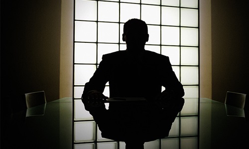Executive in silhouette in conference room