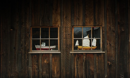 Two windows on the side of a wooden barn