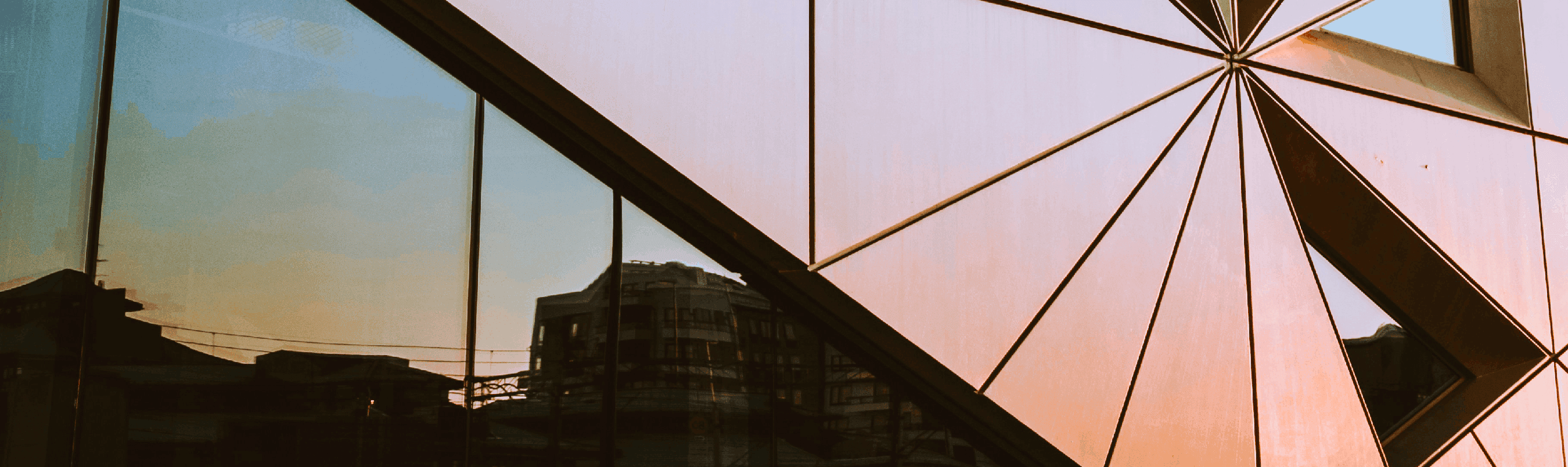 Side of a corporate building with a reflection of the skyline