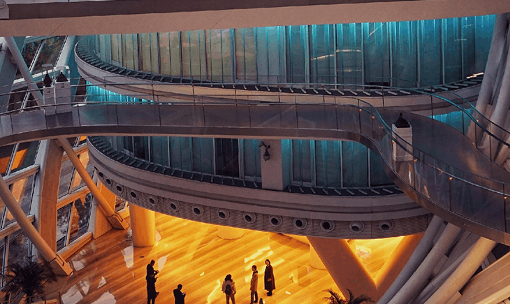 A workplace with a yellow glow, surrounded by winding staircases