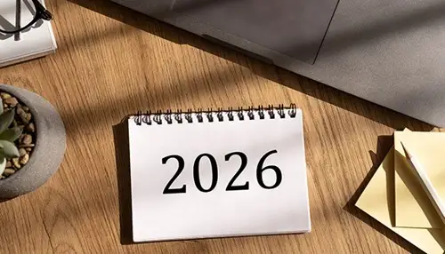 Desk calendar showing “2026” on a wooden desk.