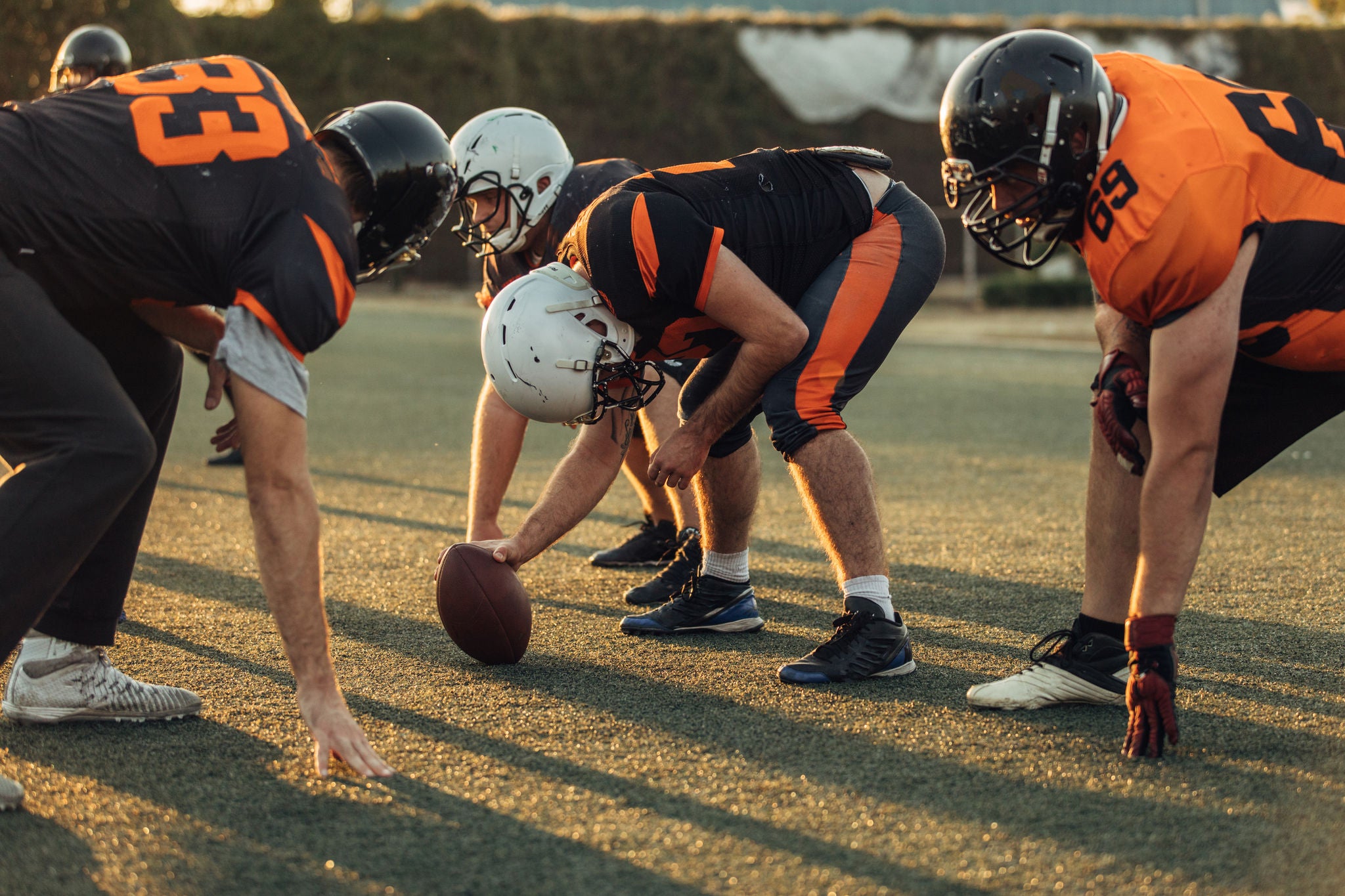 Group of men, American football players on rough training outdoors.