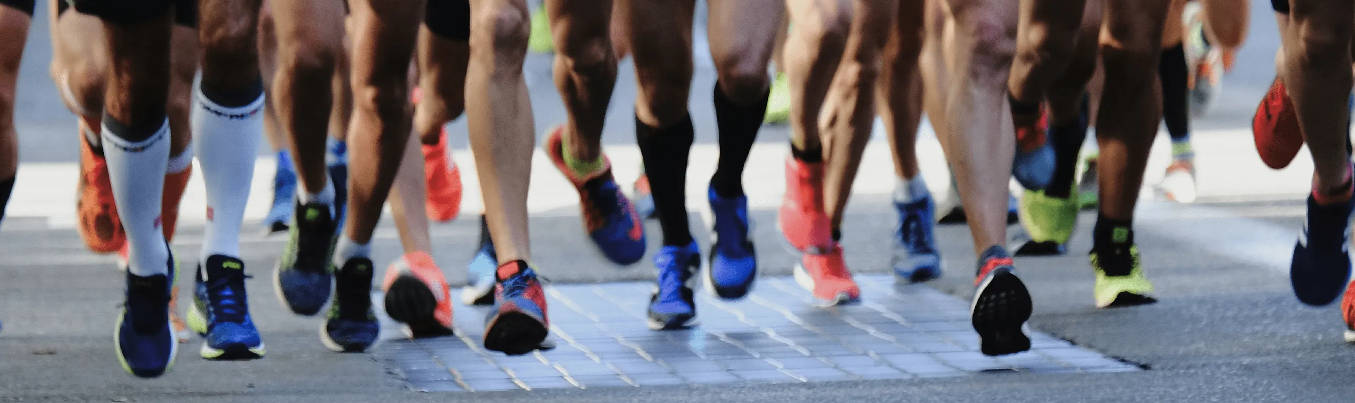 A picture of a group of runners, with only their legs showing. Meant to represent defined benefit pensions schemes moving forward on the final stretch of their journey to endgame.