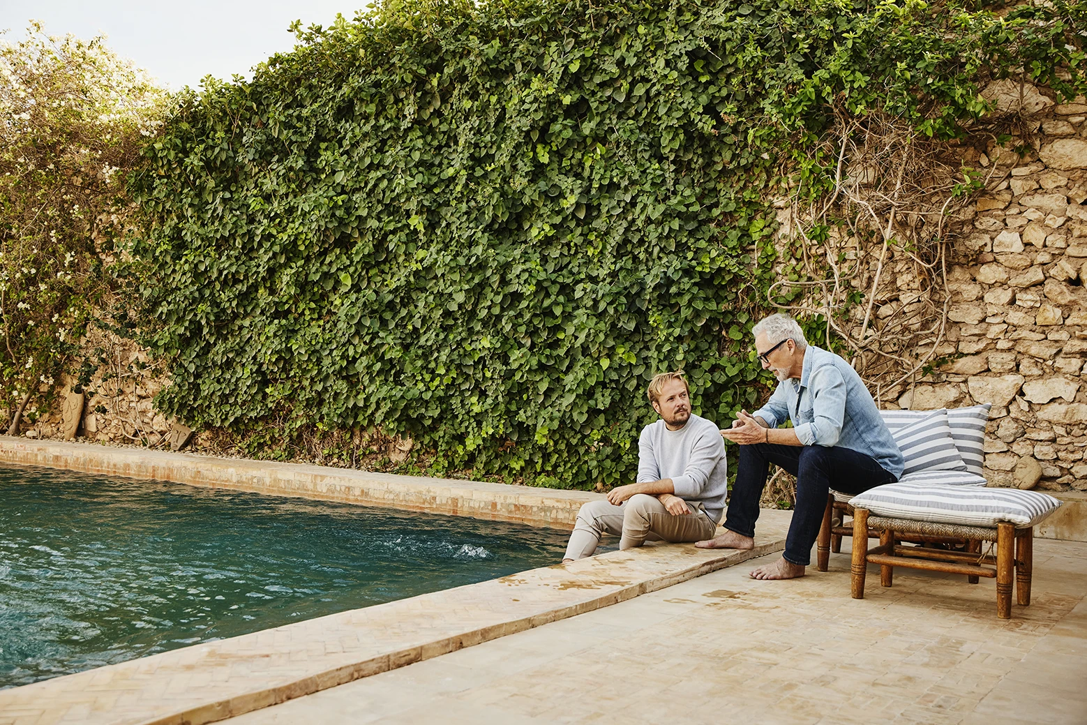 Two people talking by the side of the pool