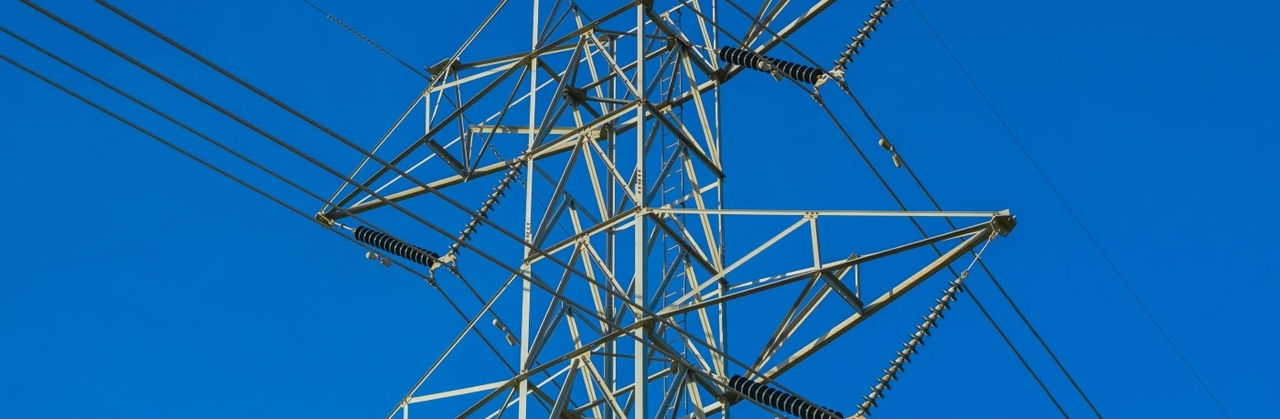 High-voltage power lines against blue sky
