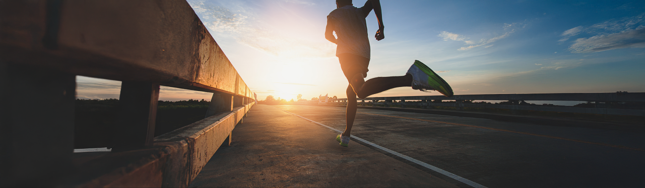 Runner at sunrise on open road