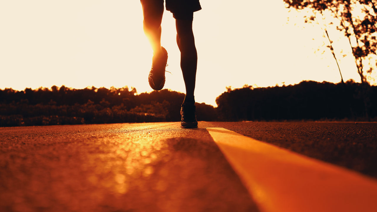 Athlete runner feet running on road, Jogging concept at outdoors. Man running for exercise.
