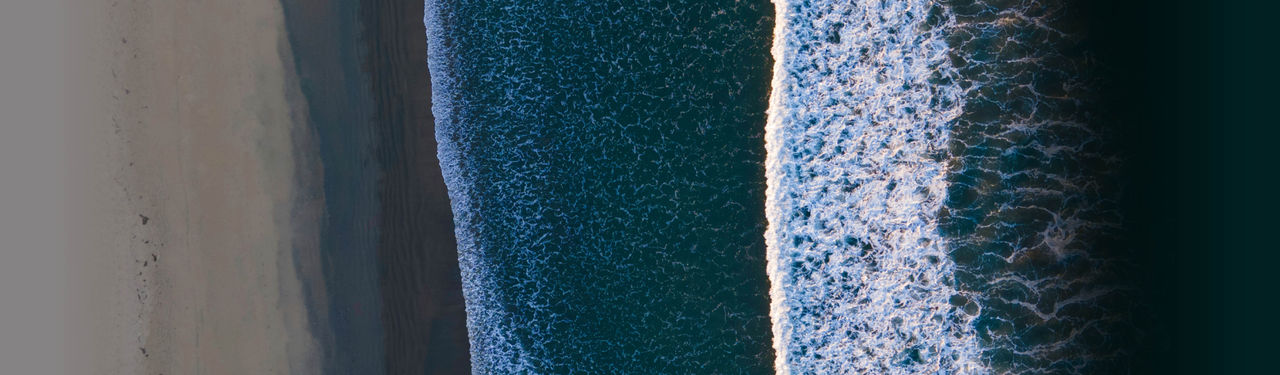 Aerial View of Ocean Waves Meeting Sandy Shore
