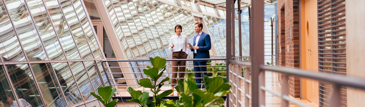 Business colleagues talking in modern glass atrium