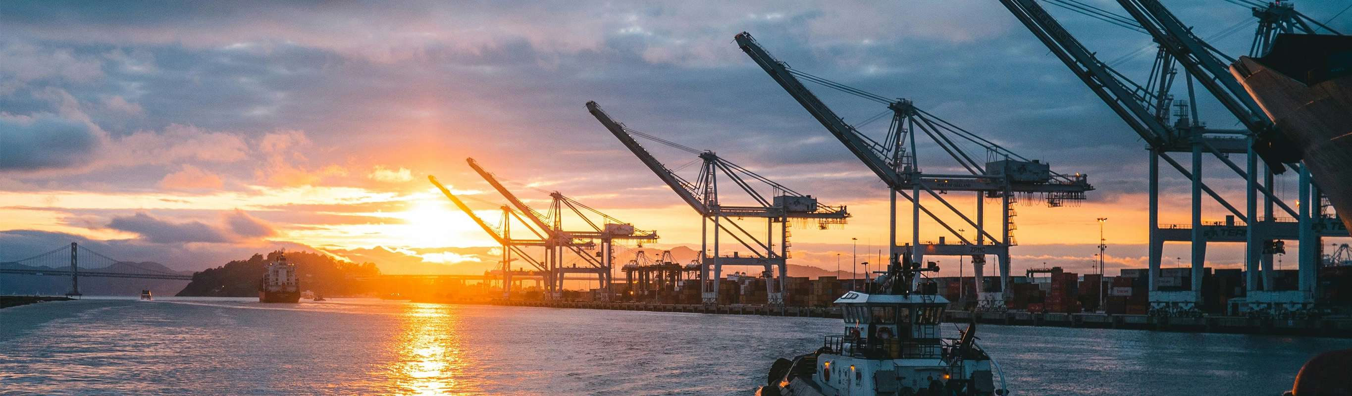 Industrial port cranes at sunset waterfront scene