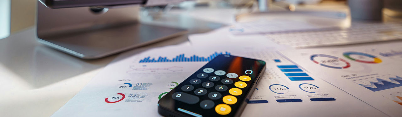 Calculator on financial charts in office