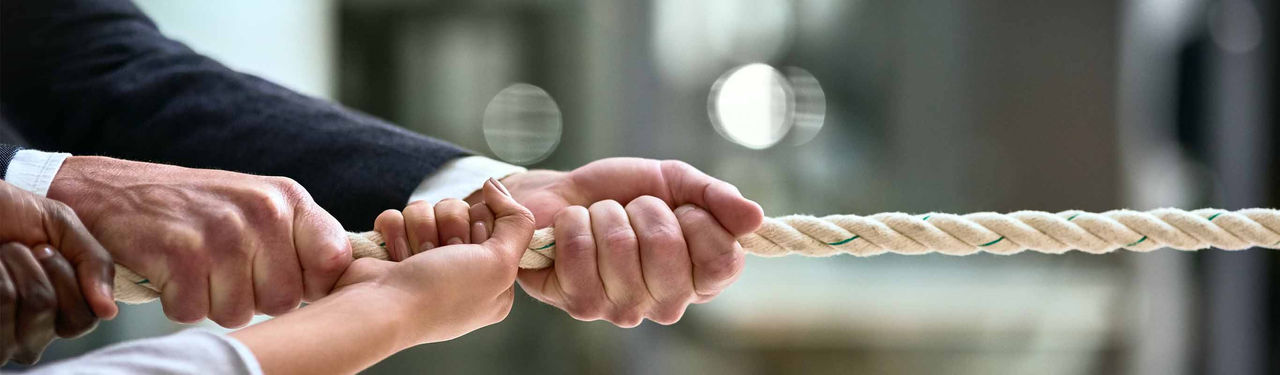 Close-up of hands pulling rope in teamwork effort