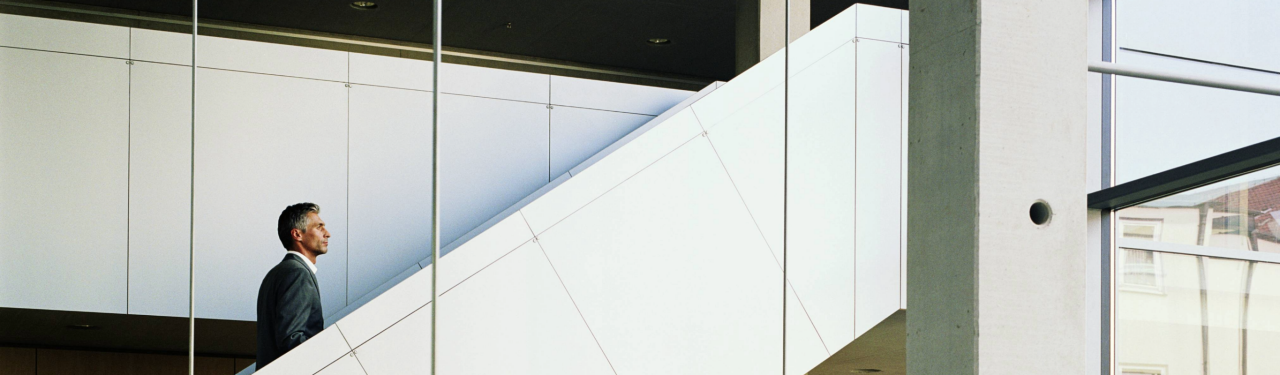 Businessman walking up modern office stairs