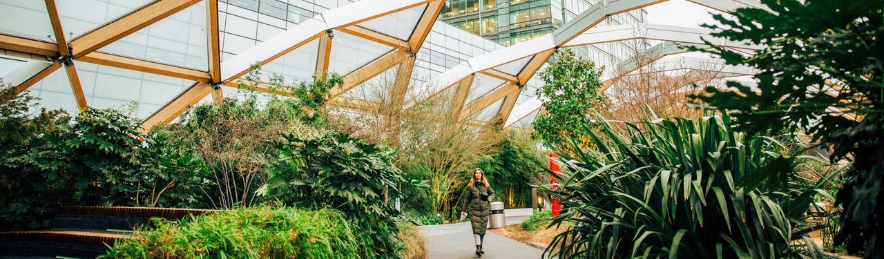 Woman walking through modern indoor garden atrium