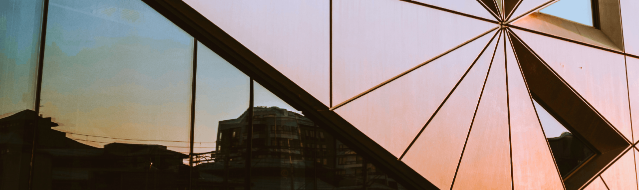 Side of a corporate building with a reflection of the skyline